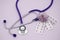 Stethoscope, three blisters with pink medical pills on a pink background with copy space. Medical flat lay