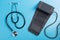 Stethoscope and tonometer on a blue background, the concept of diagnostics of heart and vascular diseases