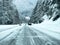 Stevens Pass, WA USA - circa December 2022: Wide view of vehicles putting on snow tire chains on the side of the road during snowy