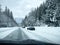 Stevens Pass, WA USA - circa December 2022: Wide view of vehicles putting on snow tire chains on the side of the road during snowy