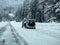 Stevens Pass, WA USA - circa December 2022: Wide view of vehicles putting on snow tire chains on the side of the road during snowy