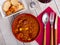 Stew of lentils with meat, chorizo and vegetables in clay bowl