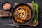 Stew veal shank meat OssoBuco, italian osso buco steak. Black wooden background. Top view
