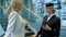 Stewardess at the airport with a phone in her hands helps passenger.