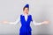 Stewardess in blue suit raises his hands to the side