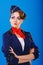 Stewardess with face art posing with folded arms.