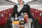 Stewardess with food trolley in cabin of airplane