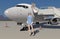 The stewardess meets passengers near the plane ladder. Vector