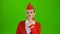 Stewardess in a red suit winks a slight flirt sends an air kiss. Green screen