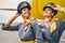 Stewardesses in pilot caps standing at the airdrome