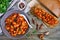 Stewed broad beans in tomato sauce with herbs and spices closeup.