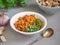 Stewed carrots with parsley and garlic in a deep plate with croutons and sheet patches in the background