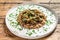 Stewed chicken stomachs with vegetables and buckwheat. Wooden background. Top view