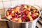 Stewed fruit and berries cooking in a pan in the kitchen. Russian berries. Compote from peach, apple, cherry and strawberry. Fresh