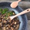 Stewed mushrooms served in a frying pan on a rough wood with fresh basil and dill greens. Bon appetit!