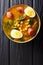 Stewed Potaje de garbanzos chickpeas, spinach, chorizo sausages, boiled eggs close-up in a bowl. Vertical top view