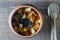 Stewed potato, carrot, onion, tomato and prunes in a clay pot on wooden background, closeup