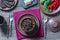 Stewed potato, carrot, onion, tomato and prunes in a clay pots with lid on wooden background, closeup