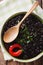 Stewed spicy black beans close up in a bowl. Vertical top view