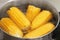 Stewpot with boiling water and corn cobs