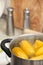 Stewpot with boiling water and corn cobs, closeup