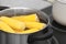 Stewpot with water and corn cobs on stove
