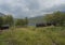 STF Teusajaure Fjallstuga Mountain cabin hut with blue Teusajaure lake, green hills, birch forest and footpath of Kungsleden