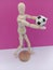 Stick person  kicking around a soccer ball with a pink backdrop for the concept of people playing sports