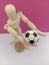 Stick person  playing with a soccer ball with a pink backdrop for the concept of people playing sports