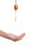 Stick spilling honey on hand on white background