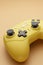 Stick of a yellow game controller close-up. Video games, entertainment at home. wireless joystick on a yellow background