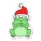 sticker of a cartoon frog wearing christmas hat