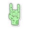 sticker of a cartoon zombie hand making horn sign