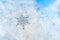 Sticker snowflakes on ice frosted window glass with blue sky seen in the background