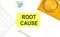 Sticker with the text ROOT CAUSE on a white background, near calculator and notebook