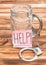 Sticker with word `Help!` on empty glass for beer and handcuffs