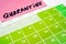 A sticker with the word quarantine on the calendar sheet. The concept of quarantine. Green days in calendar with note