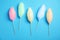 Sticks with different colorful yummy cotton candy on blue background