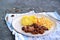 Sticky Indian style spiced chicken with a side dish of boiled potatoes and fresh cabbage salad on a white clay plate