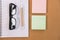 sticky note, ballpoint pen, empty notebook, eyeglasses on office