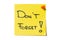 Sticky note message on yellow sticky note pinned to white background