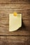 Sticky note with pin over wooden background