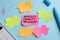 Sticky note with words Diversity, Equality, Inclusion and paper puzzle pieces on light blue background, flat lay