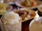 Sticky rice in small serving bamboo basket on a defocused background of variety of Thai foods