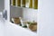 Stii live, bright and sunny detail of shelf in kitchen in house with bottles olive oil wooden bowl mortar green mediterranean