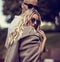 Stilish couple walking in modern dresses and trendy sunglasses on summer background. Beautiful female blond model with hoody on