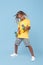 Stilish little boy with african dreads play on skateboard like on guitar over blue background. Rock music concept.