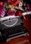 Still life - antique printing press and bright flowers on a dark background