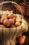 Still life of a basket full of brown eggs in a rustic farmhouse like setting, with warm side light