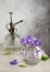 Still life with beautiful bouquet of violet false African flowers and vintage steel water sprayer at garden home